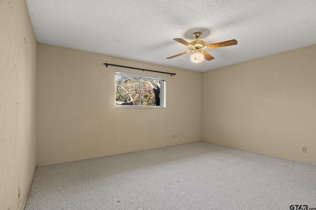 carpeted spare room with a textured ceiling and ceiling fan