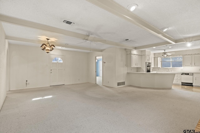 unfurnished living room with beam ceiling, ceiling fan with notable chandelier, and a textured ceiling