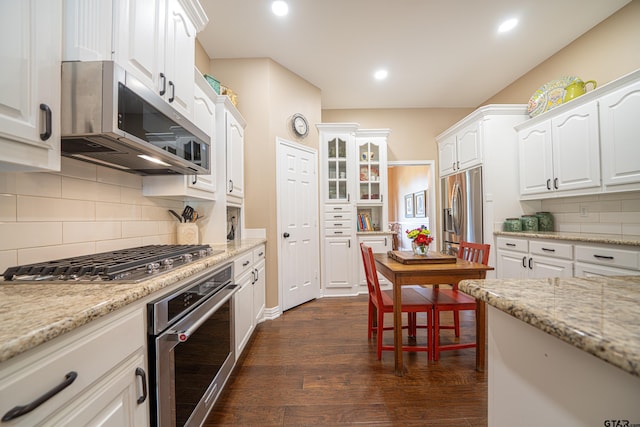 kitchen featuring appliances with stainless steel finishes, dark wood-style flooring, white cabinetry, and light stone countertops