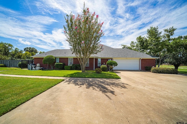 single story home featuring an attached garage, brick siding, fence, driveway, and a front lawn