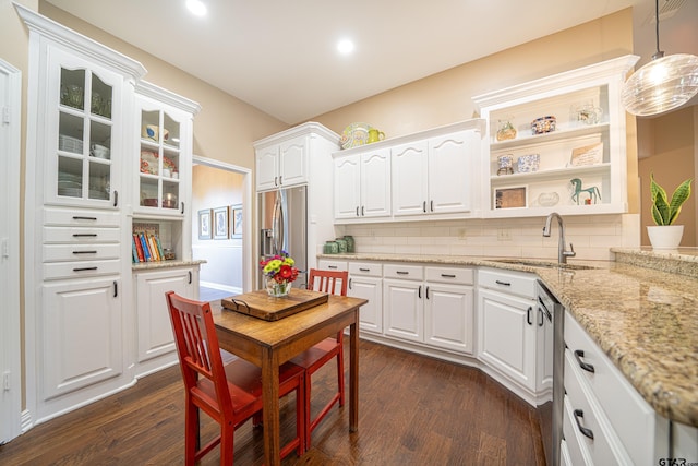 kitchen with backsplash, dark wood finished floors, stainless steel appliances, and a sink