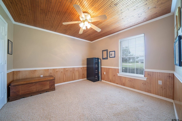 empty room with a wainscoted wall, crown molding, wooden ceiling, and wooden walls