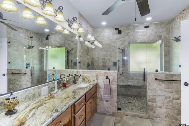 bathroom featuring vanity, a shower with shower door, and ceiling fan