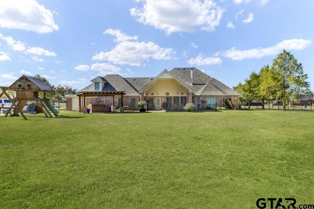 view of front facade with a hot tub, a playground, and a front yard