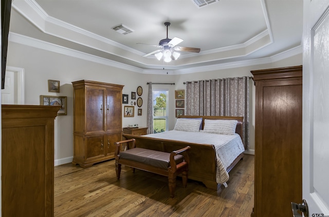 bedroom with hardwood / wood-style floors, a tray ceiling, ornamental molding, and ceiling fan