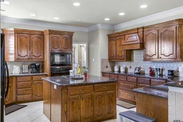 kitchen featuring premium range hood, a kitchen island, backsplash, light tile patterned floors, and black appliances