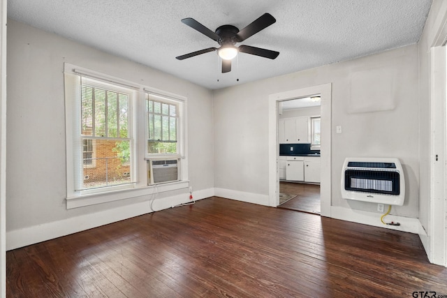 empty room with heating unit, ceiling fan, and hardwood / wood-style flooring