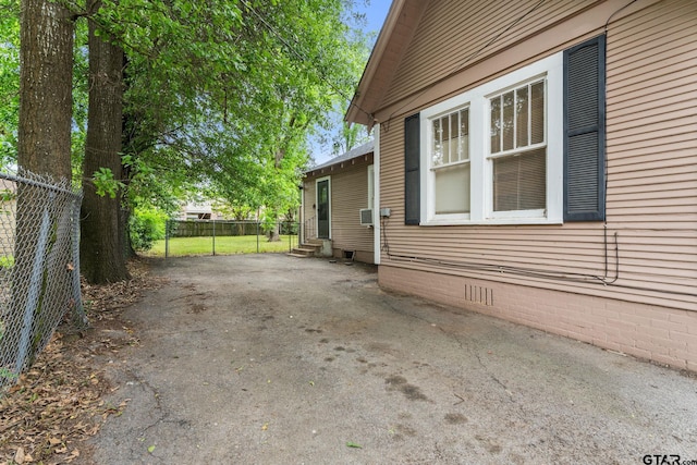 view of side of property featuring entry steps, fence, driveway, and crawl space
