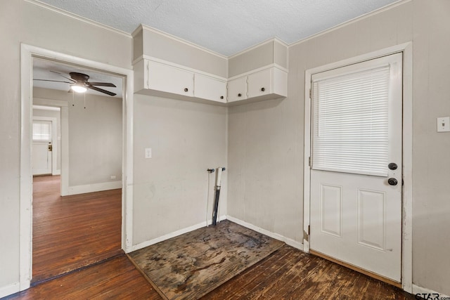 interior space featuring baseboards, a ceiling fan, dark wood-style flooring, and a textured ceiling