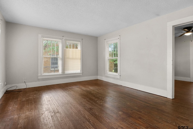 spare room featuring baseboards, wood-type flooring, a ceiling fan, and a textured ceiling