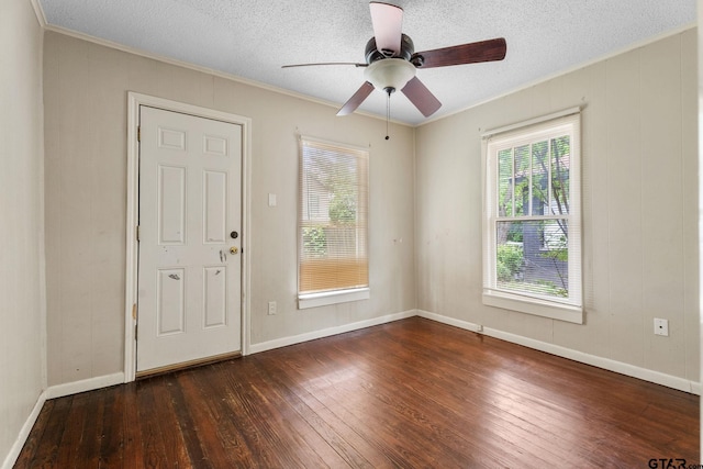 spare room featuring ceiling fan, a textured ceiling, baseboards, ornamental molding, and hardwood / wood-style floors
