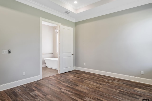 unfurnished bedroom featuring dark wood-type flooring, crown molding, and connected bathroom