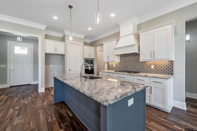 kitchen with a center island with sink, sink, custom exhaust hood, and dark hardwood / wood-style flooring