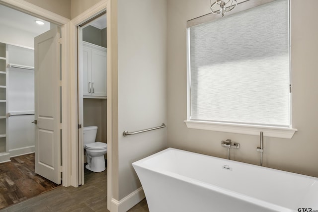 bathroom featuring a bathtub, hardwood / wood-style flooring, and toilet