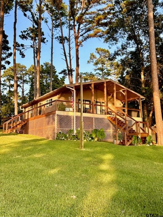 view of home's exterior featuring stairway, a wooden deck, and a yard