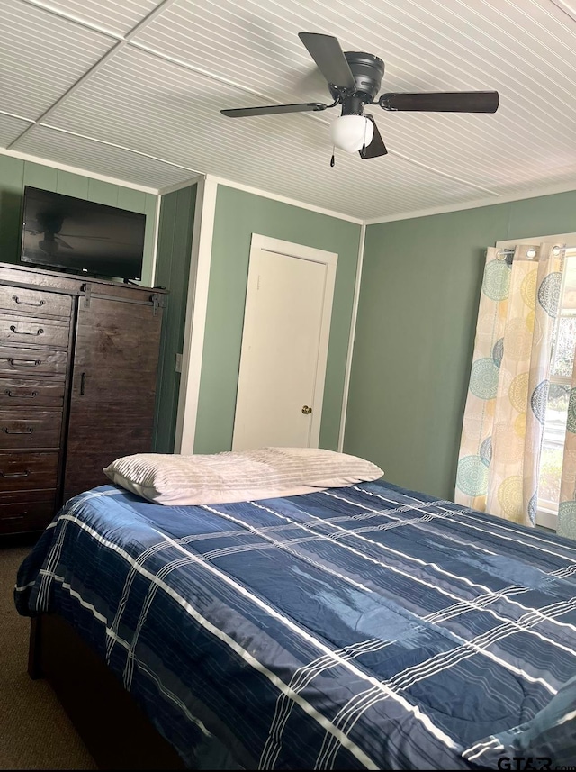 bedroom featuring carpet floors, ceiling fan, and crown molding