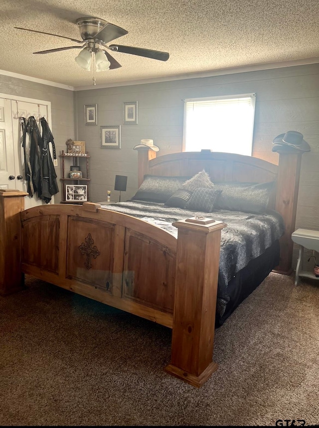 carpeted bedroom featuring a closet, a textured ceiling, ceiling fan, and crown molding