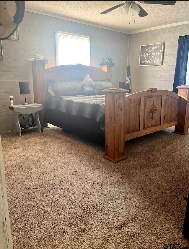 bedroom with a textured ceiling, dark colored carpet, and ceiling fan