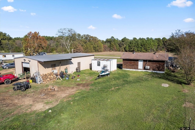 back of property with a lawn and an outdoor structure