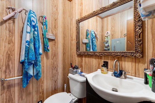 bathroom featuring wooden walls, sink, and toilet