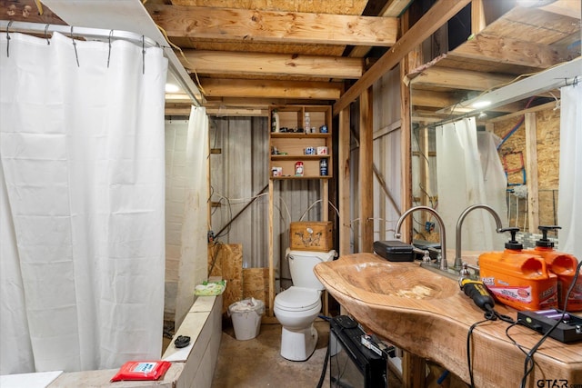 bathroom featuring concrete floors and toilet