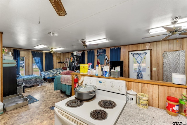 kitchen with white range with electric stovetop and wood walls