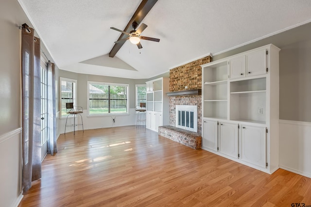 unfurnished living room with vaulted ceiling with beams, a fireplace, light wood-type flooring, a textured ceiling, and ceiling fan