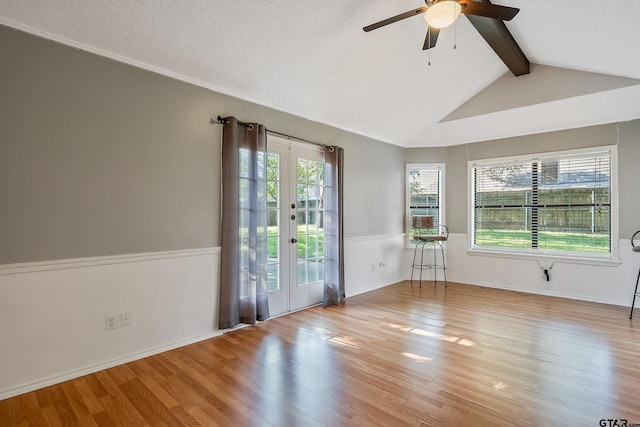 unfurnished room with lofted ceiling with beams, french doors, ceiling fan, and light hardwood / wood-style flooring