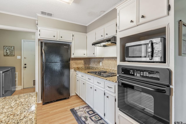 kitchen with black appliances, white cabinetry, light stone countertops, and light hardwood / wood-style flooring