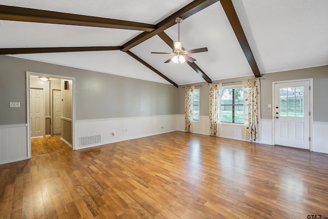 unfurnished living room with lofted ceiling with beams, light wood-type flooring, a textured ceiling, and ceiling fan