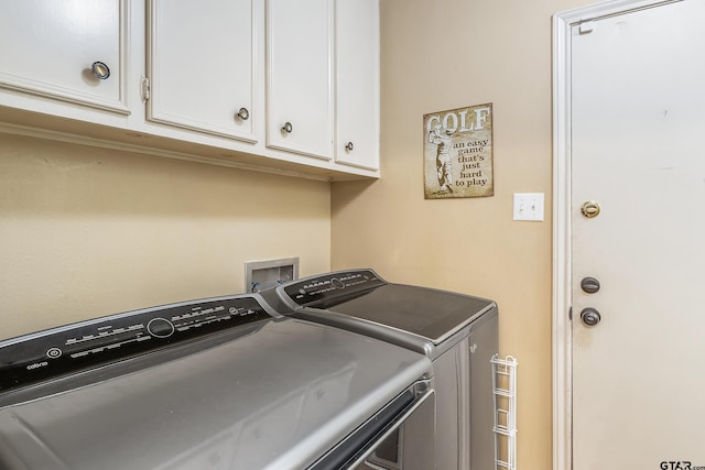 washroom with washing machine and dryer and cabinets