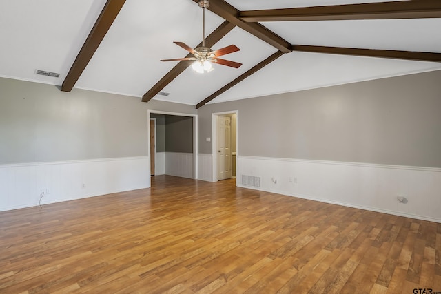 spare room featuring lofted ceiling with beams, light hardwood / wood-style flooring, and ceiling fan