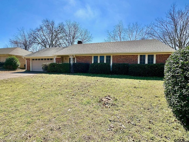 ranch-style home featuring driveway, brick siding, an attached garage, and a front yard