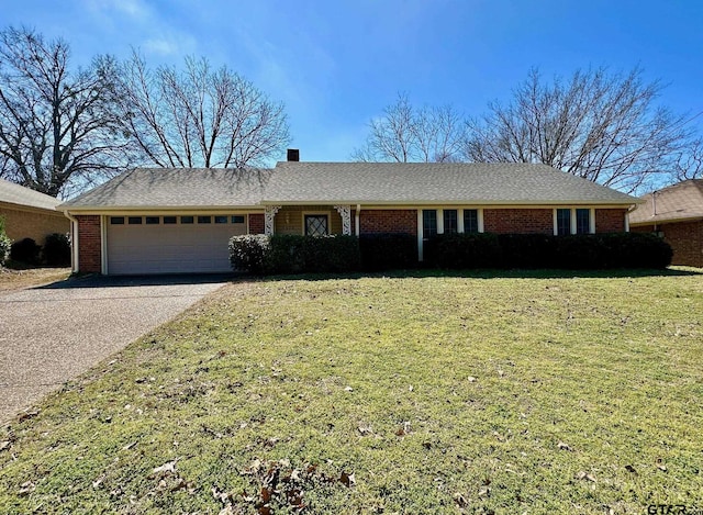 ranch-style home with a garage, driveway, a chimney, a front lawn, and brick siding