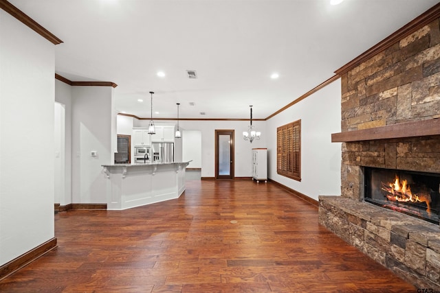 unfurnished living room featuring dark hardwood / wood-style floors, ornamental molding, and a fireplace