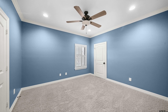 carpeted spare room featuring ceiling fan and ornamental molding