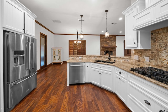 kitchen with kitchen peninsula, appliances with stainless steel finishes, white cabinetry, and hanging light fixtures