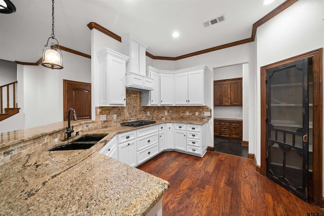 kitchen with pendant lighting, white cabinetry, sink, and black gas cooktop