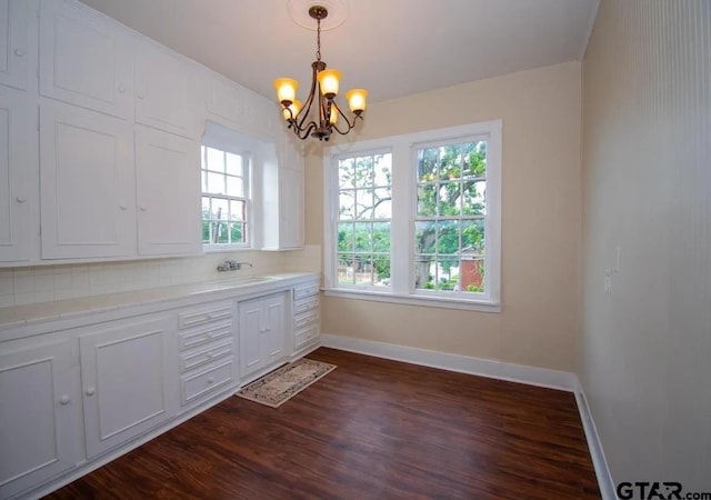 interior space with an inviting chandelier, dark wood-style flooring, baseboards, and a wealth of natural light