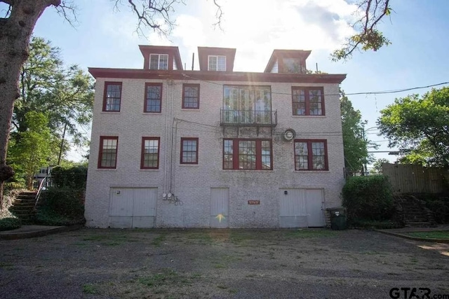 view of front of home with fence and a balcony