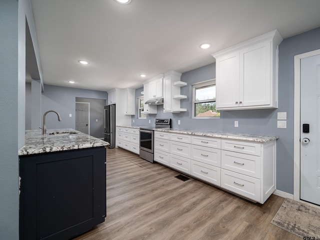 17795 Lookout Ln, Flint, TX 75762 - kitchen with a sink, wood finished floors, stainless steel appliances, and white cabinetry