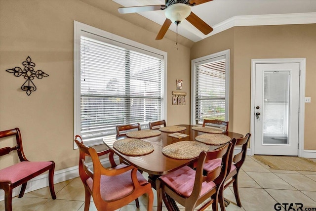 tiled dining space with a wealth of natural light, ceiling fan, and ornamental molding