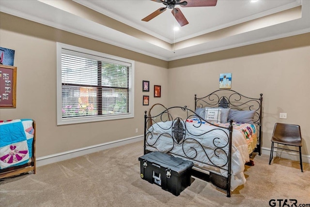 bedroom with a raised ceiling, ceiling fan, light carpet, and ornamental molding