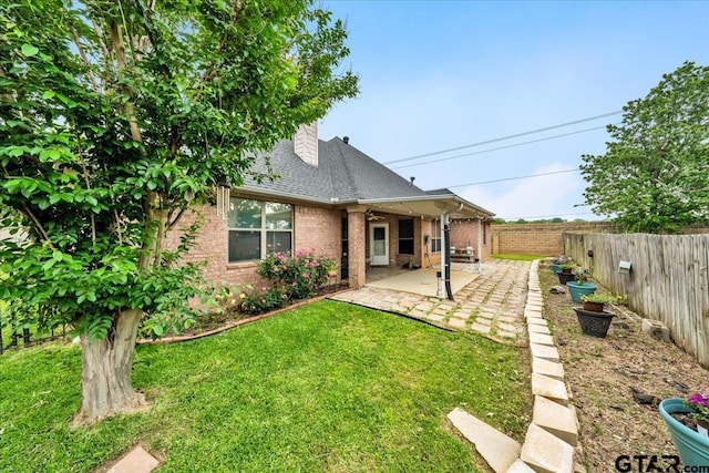 rear view of house with a lawn and a patio