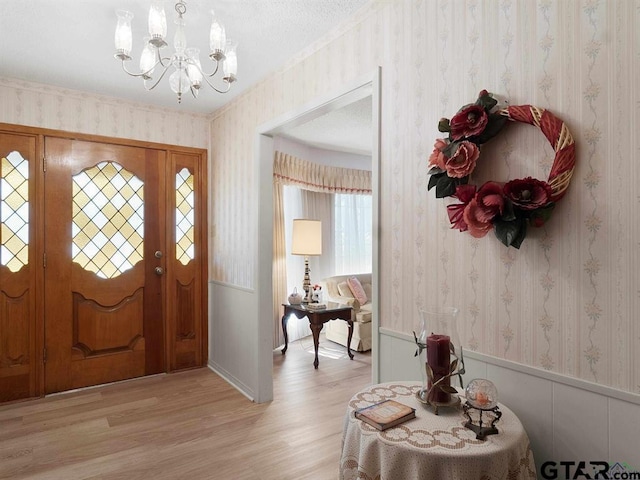 564 County Road 1100, Daingerfield, TX 75638 - entryway with wallpapered walls, a chandelier, light wood-style flooring, and a wainscoted wall