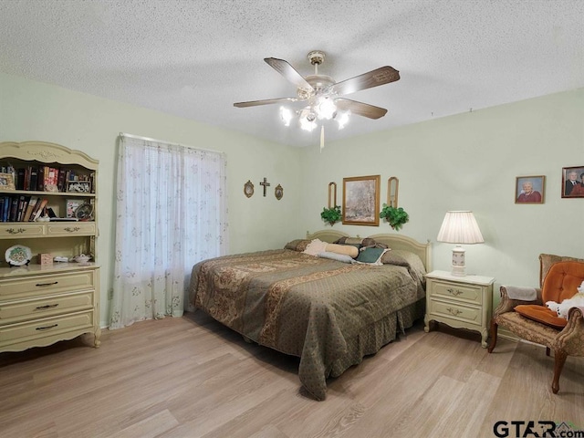 564 County Road 1100, Daingerfield, TX 75638 - bedroom with light wood-style floors, a textured ceiling, and ceiling fan