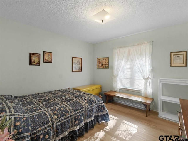 564 County Road 1100, Daingerfield, TX 75638 - bedroom with wood finished floors and a textured ceiling