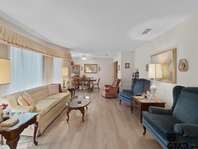 564 County Road 1100, Daingerfield, TX 75638 - living room with light wood-style floors, a textured ceiling, and ceiling fan