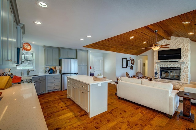 kitchen featuring open floor plan, light countertops, stainless steel appliances, dark wood-type flooring, and ceiling fan