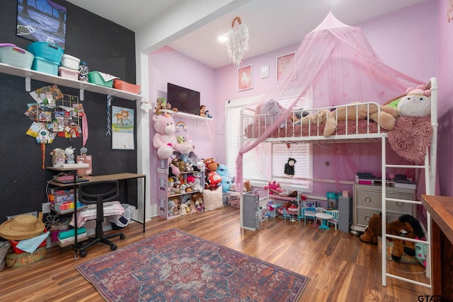 bedroom featuring an inviting chandelier and hardwood / wood-style floors